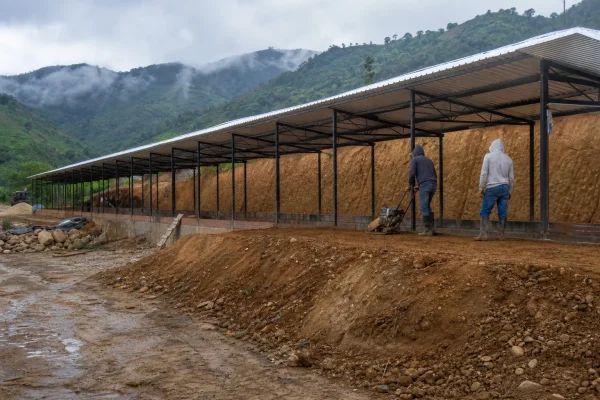 Galpón en construcción sobre una explanación en ladera con corte y lleno de tierra